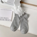Calcetines de punto gris con encaje blanco floral en un entorno de estilo minimalista - Gris
