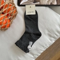 Dark grey crew socks featuring delicate white lace bow detail and ribbed knit texture - One Size / Smoke