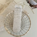 Beige Rüschensocken mit bunten Punkten und Schleife in einem rustikalen Korb - Punktgarn Agaric Spitze Stil