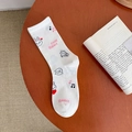 Cute white crew sock with cartoon rabbit patterns and book props on a wooden table - Note Rabbit