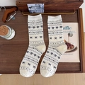 Calze color crema con motivi di cuori e fiocchi grigi su sfondo in legno naturale - Taglia unica / Bianco