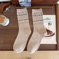 Calze beige in maglia con cuori blu e fiocchi neri su un vassoio di legno - Taglia unica / Caffè Chiaro