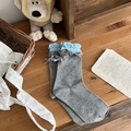 Calze di cotone pettinato grigio con bordi a balze azzurri e un fiocco decorativo - grigio scuro