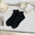 Calcetines negros de algodón acanalado para mujer en un entorno de estilo minimalista - Negro puro