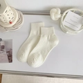 Calcetines blancos de algodón acanalados en un entorno minimalista con accesorios - Blanco Puro