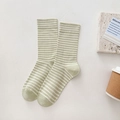 Light green and white striped cotton mid-calf socks displayed on a warm textured surface - One Size / Green Stripes