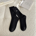 Chaussettes noires en coton côtelé avec broderie nœud argenté sur un fond texturé doux - Taille unique / Noir