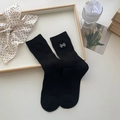 Schwarze Socken mit weißer Schleifenbestickung und Rippbündchen auf Holztablett - Einheitsgröße / Schwarz