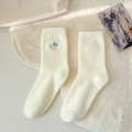Creamy white plush winter socks with blue bird embroidery and soft coral fleece texture - Duck
