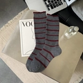 Grey knit crew socks with burgundy stripes and ruffled edges in a cozy desk setting - Grey Horizontal Stripe
