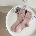 Calze in cotone rosa con ricamo a fiocco bianco e bordi a volant su un piatto bianco - Fiocco Ricamato - Rosa