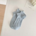 Light blue knit socks featuring elegant white bow embroidery and delicate cable texture - Blue