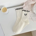 Cremeweiße Baumwollsocken mit schwarzem Wellensaum und Schleifen-Stickerei-Detail - Schwarze Schleife Stil