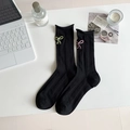 Black ribbed crew socks with colorful bow embroidery on a minimalist white desk setup - One Size / Black