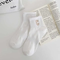 White cotton crew socks with brown embroidered letter C on a minimalist magazine background - White Embroidery C