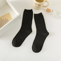 Minimalist black crew socks in ribbed cotton blend presented in a cozy lifestyle setting - One Size / Black