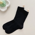 Black ribbed mid-calf cotton socks featuring white label with yellow smiley face - Black