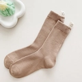 Brown mid-calf ribbed knit socks with a white smile face label on a minimalist background - Brown