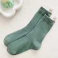 Calzino verde salvia a coste con etichetta decorativa smiley e scritta good luck - Ciano