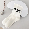 White ribbed crew socks with black 1977 numeral print in a minimalist studio setting - One Size / White 1997