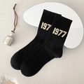 Black mid-calf cotton socks featuring beige 1977 knit numbers on a white tray - One Size / Black 1997