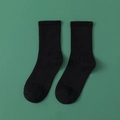 Schwarze, minimalistische Ripp-Baumwollsocken auf dunkelgrünem Hintergrund - Schwarz