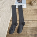 Chaussettes montantes gris foncé en maille côtelée sur un fond de parquet vintage - Gris