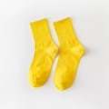 Solid yellow cotton mid-calf socks with ribbed cuffs shown in a flat lay minimalist style - One Size / Turmeric