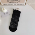 Sheer black mid-calf socks with abstract swirl patterns and ruffled edge on white display - One Size / Black Rhythm Waves