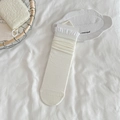 Ballet style white crew socks with ruffled cuffs and ribbed texture in minimalist packaging - Cream