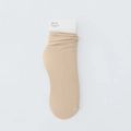 Beigefarbene gerippte Stricksocken mit Papieranhänger im minimalistischen Stil - Hautfarben