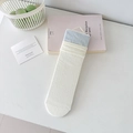 Cream-white crew socks with light blue ribbed cuffs in retail packaging on a desk - Light Blue Color Block Cuff Style