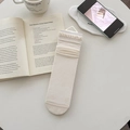 Chaussettes en soie crème avec motifs de cœur et bords à volants sur fond lifestyle - Kaki
