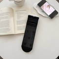 Chaussettes en soie noire à motif de cœur avec bords volantés dans un décor de style de vie - Noir