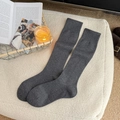 Deep grey knitted wool calf socks with ribbed cuffs for women in a cozy winter setting - One Size / Dark Gray