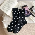 Dicke schwarz-weiße gepunktete Wintersocken mit Nice-Label auf warmem Vlies-Hintergrund - Einheitsgröße / Schwarz