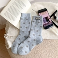 Dicke hellblaue Socken mit grauen Punkten und Nice-Label auf weichem weißem Teppich - Einheitsgröße / Hellblau