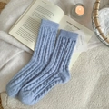 Light blue knit socks with cable pattern and colorful dots on a cozy white fleece blanket - One Size / Dark Blue