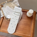 Chaussettes élégantes gris clair à fleurs bleues sur un plateau en bois rustique - Blanc Cassé