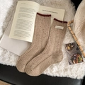 Haferfarbene Wollsocken mit tiefrotem Rippbund und modischem Textiletikett - Milchtee