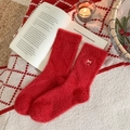 Festliche rote Fleece-Socken mit goldener Stickerei in gemütlicher Winterkulisse - Bestickte Schleife