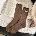 Dicke dunkelbraune Wollsocken mit bunten Tupfern und weißem Textiletikett-Detail - Hellkaffee