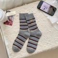 Graue Crew-Socken mit bunten Streifen und Brot-Stickerei in gemütlicher Umgebung - Einheitsgröße / Baguette