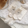 Calze di cashmere color crema con ricamo su un accogliente sfondo di peluche - Taglia unica / Bianco