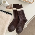 Dunkelbraune gerippte Wollsocken mit grauen Streifen in einer gemütlichen Kulisse - Dunkelbraun
