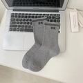 Calze grigie in cotone con strisce nere e numero 05 su sfondo di computer portatile - grigio scuro