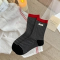 Striped cotton crew socks with red trim and egg label in a high-quality lifestyle shot - Black