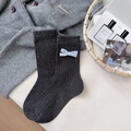 Dunkelgraue Socken mit blauer Schleife und gesprenkeltem Strick auf Wollmantelhintergrund - Einheitsgröße / Dunkelgrau