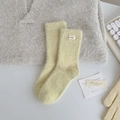 Light yellow mink cashmere socks with wave-edged handmade label in warm home setting - Lemon Yellow