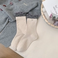 Calze di cotone beige con bordo ondulato grigio scuro e motivi a cuore in stile flat lay - Farina d'avena